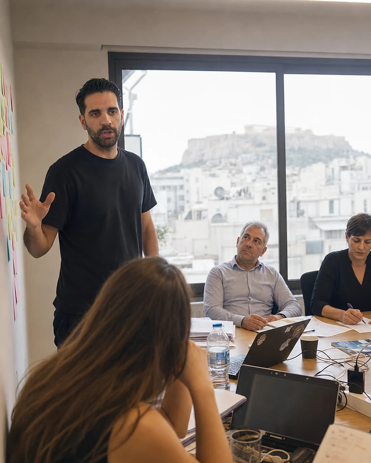 Ομάδα σε workshop AI Awakening, μπροστά σε τοίχο με sticky notes